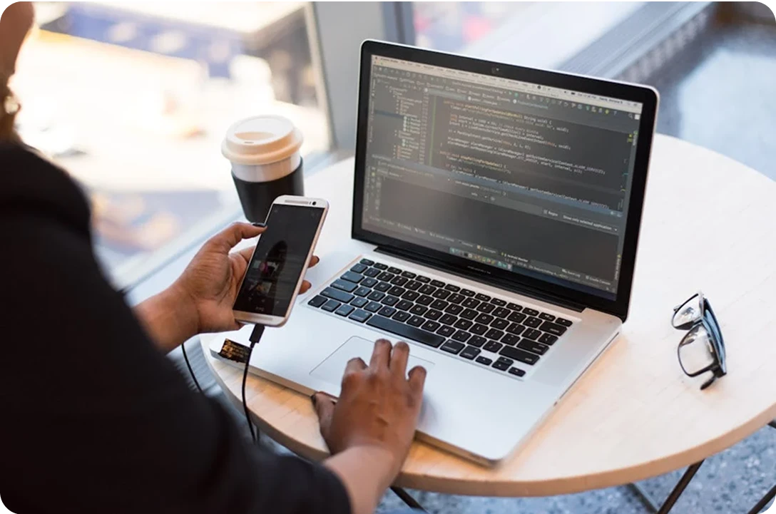 Developer working on a laptop with abstract digital elements and code in the background