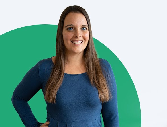 Expertin Vanessa lächelt freundlich vor einem modernen Designhintergrund