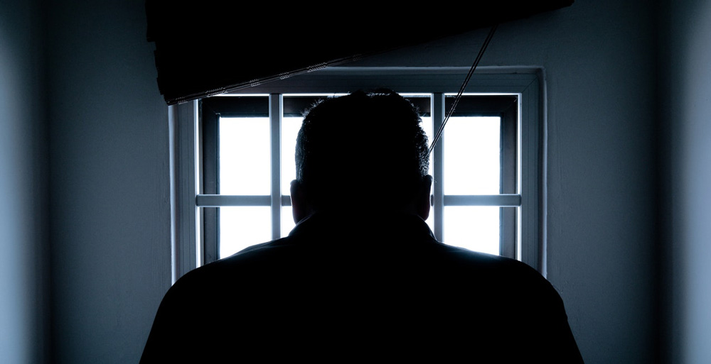 Silhouette eines Mannes vor hellem Fenster