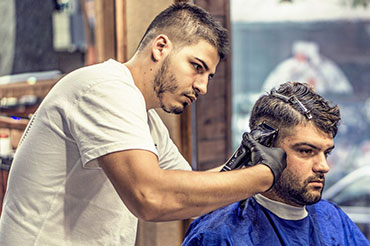 Friseur schneidet Kunden die Haare