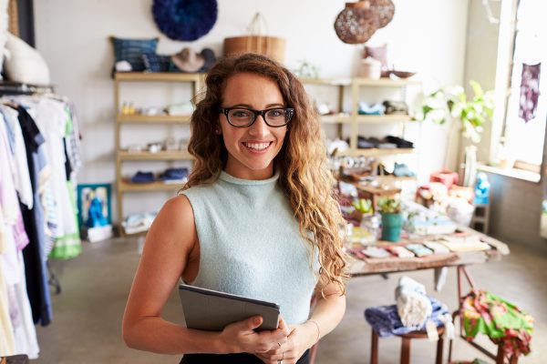 Person mit Tablet vor Regalen