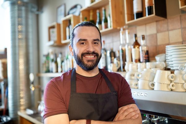 freundlicher Mann mit Schürze in Café